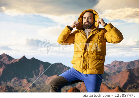 Traveler takes in the breathtaking mountain landscape and beautiful peaks, high altitude view with fresh air and panoramic sky creates a peaceful setting for relaxation. Self improvement. Traveler takes in the breathtaking mountain landscape and beautiful peaks, high altitude view with fresh air and panoramic sky creates a peaceful setting for relaxation. Self improvement. 125857473