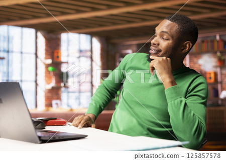 Freelancer in home office sitting at desk and typing on laptop keyboard. Remote employee using electronic device to do customers relations job online, answering inquiries Freelancer in home office sitting at desk and typing on laptop keyboard. Remote employee using electronic device to do customers relations job online, answering inquiries 125857578