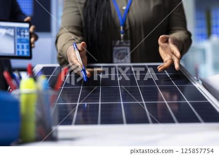 Scientists conduct research and development on solar panel efficiency, analyzing photovoltaic materials in high tech factory to enhance renewable energy production, close up shot 125857754