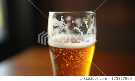 Empty beer glass with foam on the table at the bar in warm lighting Empty beer glass with foam on the table at the bar in warm lighting 125857990