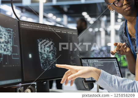 Close up of manager supervising admin using computer in data center office, integrating AI driven automation tools. Server farm team leader and worker use artificial intelligence deep learning models Close up of manager supervising admin using computer in data center office, integrating AI driven automation tools. Server farm team leader and worker use artificial intelligence deep learning models 125858209