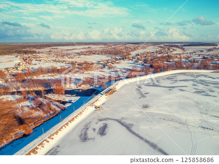 Aerial view of the frozen lake and dam in winter Aerial view of the frozen lake and dam in winter 125858686