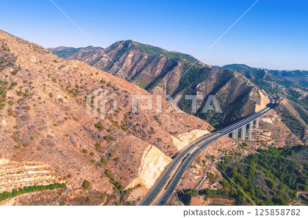 View from above Mountain landscape with viaduct. Honey Viaduct on Mediterranean Highway. Viaducto del Miel on Autovia del Mediterraneo. Malaga, Spain 125858782