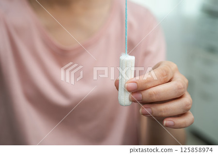 Asian woman holding cotton tampons for hygiene menstrual period cycle protection. Asian woman holding cotton tampons for hygiene menstrual period cycle protection. 125858974
