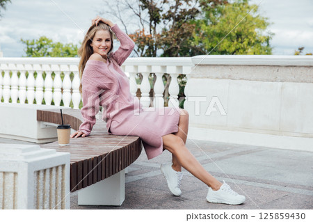 woman in pink dress drinking coffee cocktail with straw woman in pink dress drinking coffee cocktail with straw 125859430