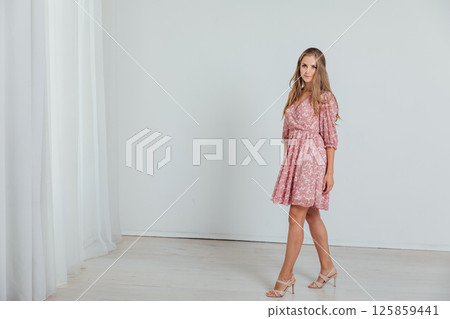 Beautiful blonde woman in summer pink dress on white background Beautiful blonde woman in summer pink dress on white background 125859441