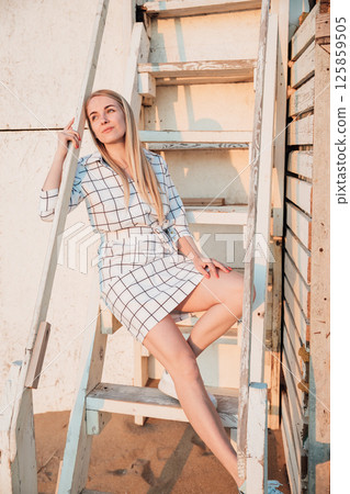 Beautiful woman smiling in summer dress on the beach by the sea 125859505