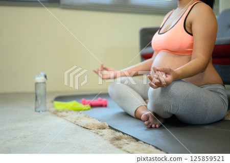 Pregnant woman practicing meditation at home for prenatal wellness 125859521