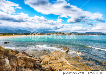 Astonishing view on  Nora bay and beach, the medieval Sant Efisio church near the shore. 125860109