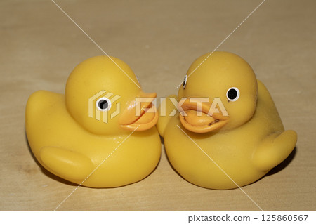 Two Cute Toy Yellow Rubber Ducks Looking Jolly on a Wood Shelf 125860567