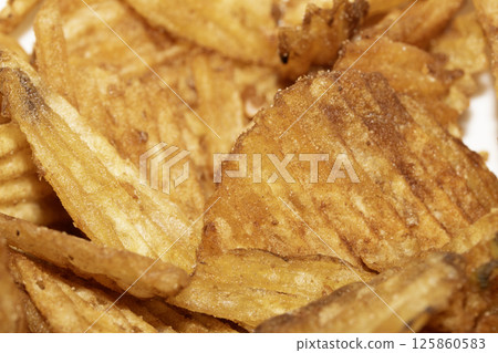 Close up of fresh crinkle cut seasoned crisps snack Close up of fresh crinkle cut seasoned crisps snack 125860583