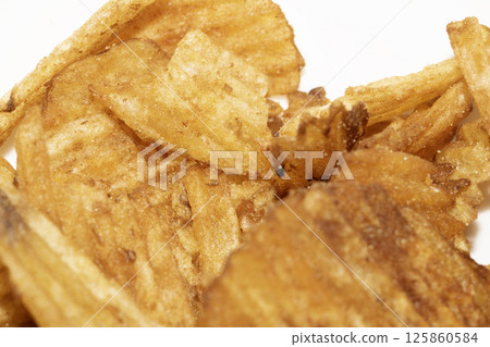 Close up of fresh crinkle cut seasoned crisps snack Close up of fresh crinkle cut seasoned crisps snack 125860584