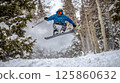 Snowboarding extreme sport. Man active sport lover snowboarder in motion over snowy mountains background. Tourism and travel. 125860632
