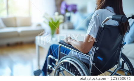 man in a wheelchair listening to music through headphones outdoors at sunset 125860675