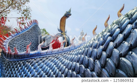 Majestic Dragon Sculpture on Temple Roof in Clear Blue Sky 125860932