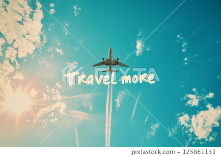 A jet airplane makes a contrail spelling out "Travel More" against a vibrant blue sky. Evoking the spirit of travel, adventure, and exploration. For travel-themed promotions or inspirational visuals. A jet airplane makes a contrail spelling out "Travel More" against a vibrant blue sky. Evoking the spirit of travel, adventure, and exploration. For travel-themed promotions or inspirational visuals. 125861131