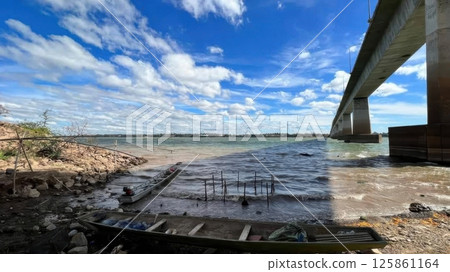 Tranquil Riverside Scene Under a Modern Bridge in Daylight 125861164