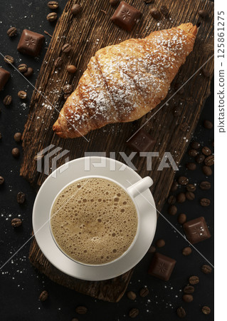 Croissant and cappuccino on wooden table, top view, fine porcelain tableware, luxury cafe Croissant and cappuccino on wooden table, top view, fine porcelain tableware, luxury cafe 125861275