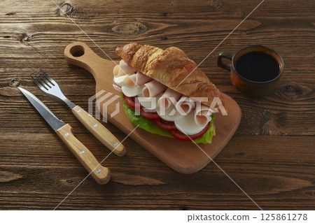 Eating out concept, Sandwich with ham and vegetables and cup of black coffee on wooden table,  125861278
