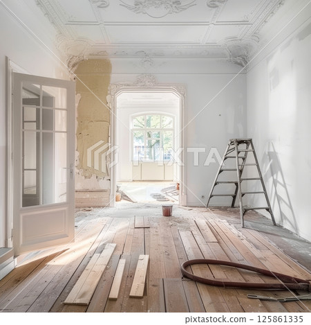 A room undergoing renovation reveals its original ornate plasterwork and hardwood floors, showing the process of restoration and detail of the classical interior 125861335