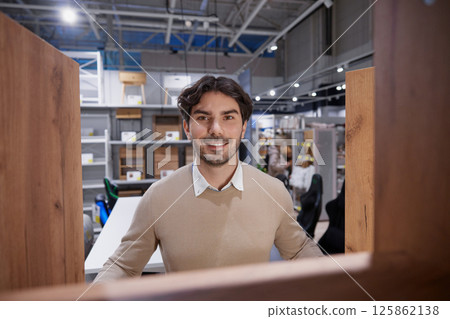 Man stands confidently with bright smile embodying success in modern, contemporary work environment Man stands confidently with bright smile embodying success in modern, contemporary work environment 125862138