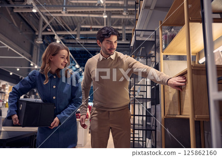 A couple is happily exploring a furniture store together, enjoying the experience and atmosphere A couple is happily exploring a furniture store together, enjoying the experience and atmosphere 125862160