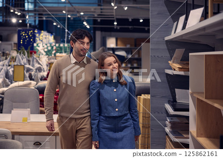 A couple enthusiastically shopping for stylish furniture in a contemporary modern store 125862161