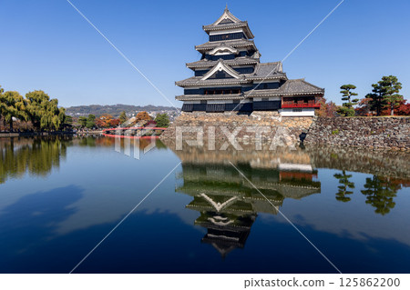 Crisp autumn scenery at Matsumoto Castle, where the historic structure, red bridge 125862200