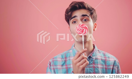Young man eating swirl candy lollipop sugar snack copy space 125862249