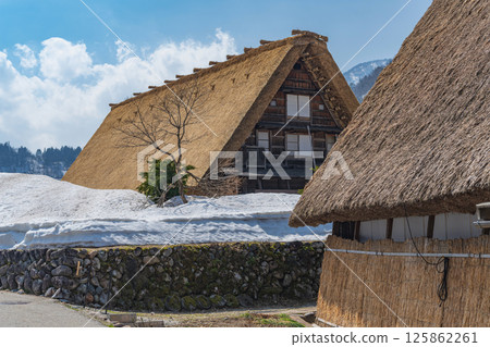 Snow melts in Shirakawa-go Gassho-style houses in the remaining snow Snow melts in Shirakawa-go Gassho-style houses in the remaining snow 125862261