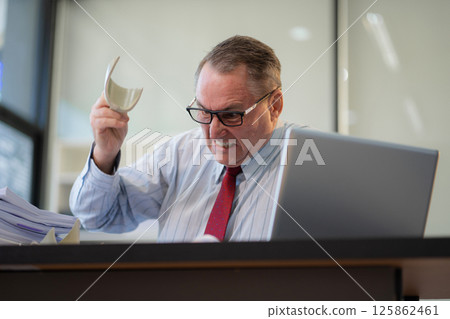 Stressed caucasian maturebusinessman working in the office. Stressed caucasian maturebusinessman working in the office. 125862461