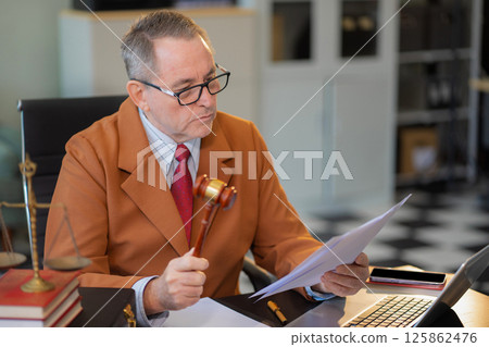 Lawyer working on a monograph in courtroom. Lawyer working on a monograph in courtroom. 125862476
