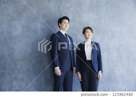 Men and women in suits standing 125862480