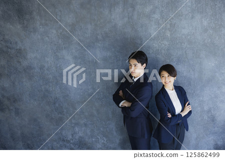 穿著西裝的男人和女人站著 穿著西裝的男人和女人站著 125862499