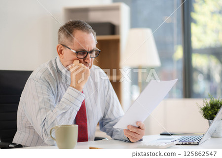 Stressed mature businessman working in the office. Businessman thinking too much work concept in the office. Stressed mature businessman working in the office. Businessman thinking too much work concept in the office. 125862547