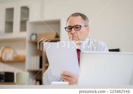 Stressed mature businessman working in the office. Businessman thinking too much work concept in the office. Stressed mature businessman working in the office. Businessman thinking too much work concept in the office. 125862548