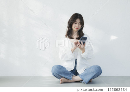 一個操作智能手機的年輕女子 125862584