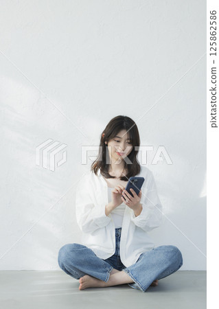 A young woman operating a smartphone A young woman operating a smartphone 125862586