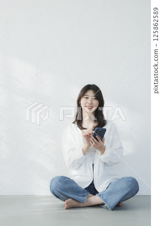 一個操作智能手機的年輕女子 125862589