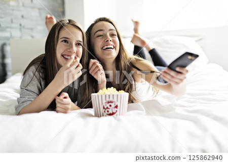 friendship, people, pajama party, entertainment and junk food concept 125862940