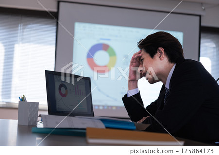 A man in a suit having trouble at work A man in a suit having trouble at work 125864173