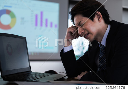 A man in a suit having trouble at work 125864176