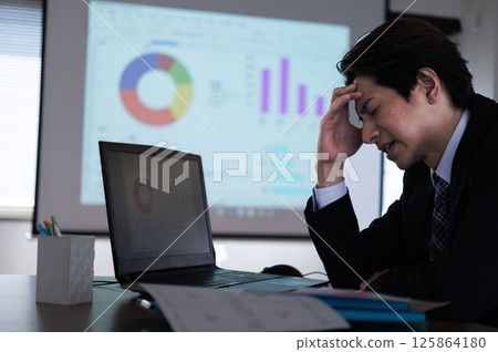 A man in a suit having trouble at work 125864180