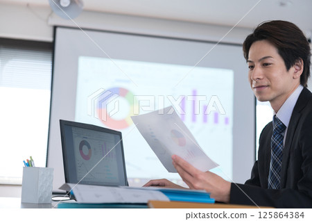 一個穿著西裝的年輕人正在工作 125864384