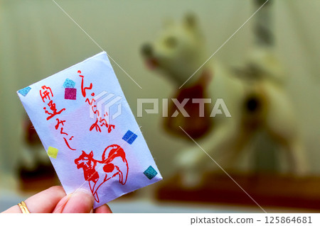 [Kagawa] Kotohira Shrine in early summer: A woman's hand holding a Konpira dog fortune slip 125864681