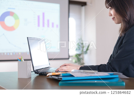 A young woman in a suit working 125864682