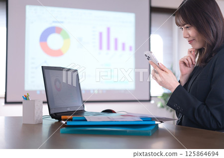 一位身著西裝的年輕女子正在工作 125864694
