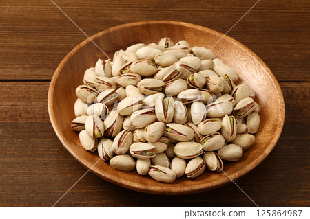 Pistachios on a wooden plate Pistachios on a wooden plate 125864987