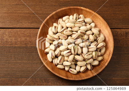 Pistachios on a wooden plate Pistachios on a wooden plate 125864989