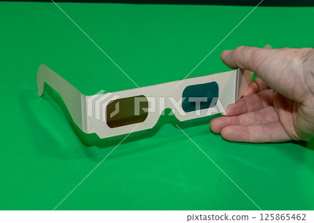 A Hand Holding 3d Glasses for Cinema with a Chroma Background A Hand Holding 3d Glasses for Cinema with a Chroma Background 125865462